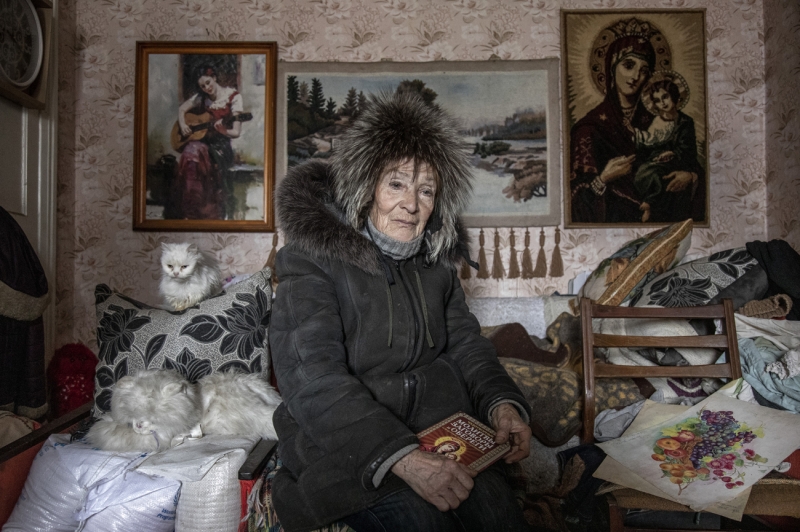 A WOMAN IS PHOTOGRAPHED IN A WAR-TORN CITY